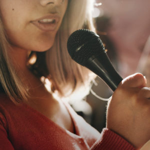 Cropped photo of woman speaking into a microphone